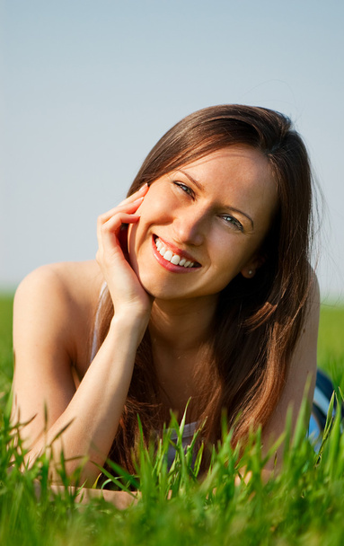 Молода жінка розслабляється на траві
 - Фото, зображення