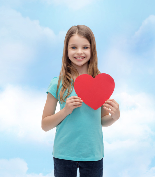 smiling little girl with red heart - Фото, изображение