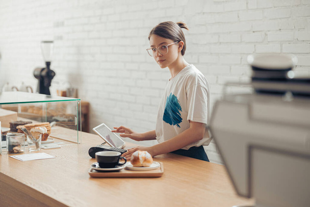 コーヒーショップで働く美しい若い女性 - 写真・画像