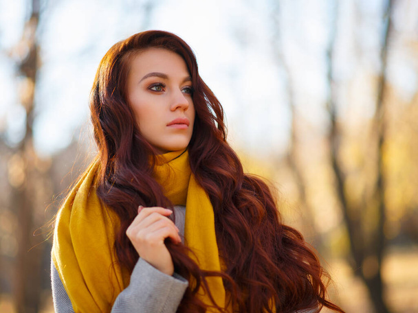 Portrait of beautiful young woman walking outdoors in autumn park - Photo, Image