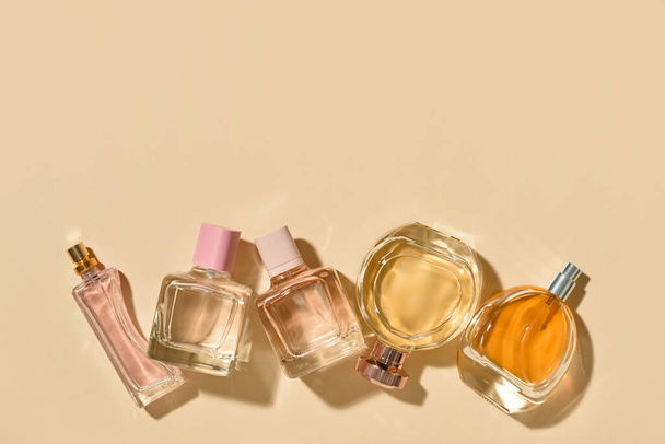 Different bottles of elegant perfumes on color background - Photo, image