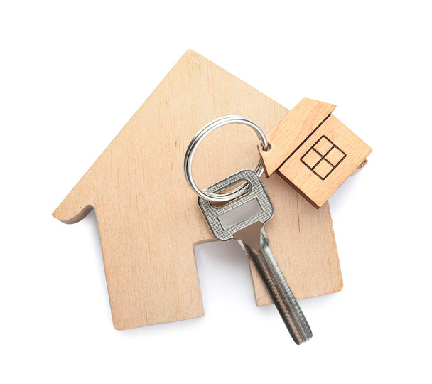 Drewniana figura domu i klucza z brelokiem na białym tle - Zdjęcie, obraz
