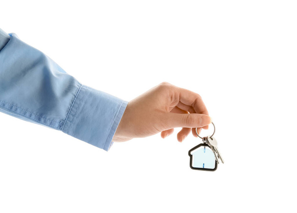 Real estate agent holding keys with house shaped keychain on white background - Photo, Image