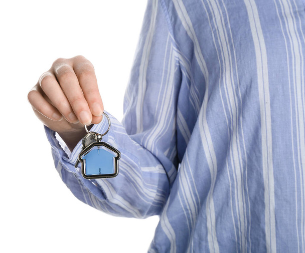 Woman holding key with house shaped keychain on white background, closeup - Photo, Image