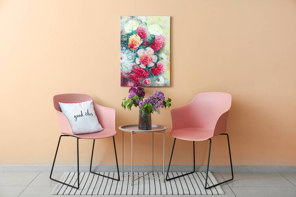 Nowoczesne różowe krzesła i szklany wazon z liliowymi kwiatami na stole w pobliżu ściany kolor - Zdjęcie, obraz