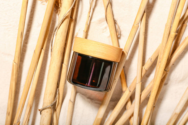 Βάζο καλλυντικού προϊόντος με μπαμπού sticks σε φόντο άμμου - Φωτογραφία, εικόνα