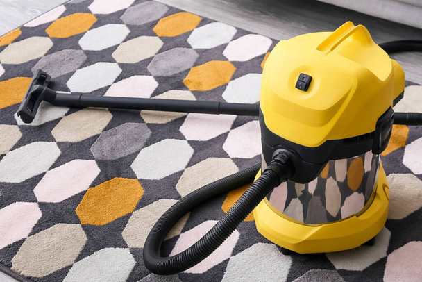 Vacuum cleaner on carpet in room - Φωτογραφία, εικόνα