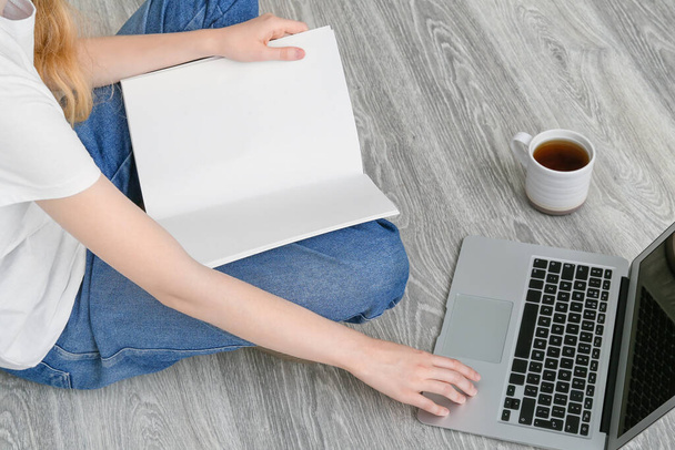 Donna con rivista bianca che lavora su laptop - Foto, immagini