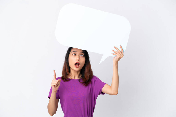 Young Vietnamese woman isolated on white background holding an empty speech bubble and thinking - Photo, image