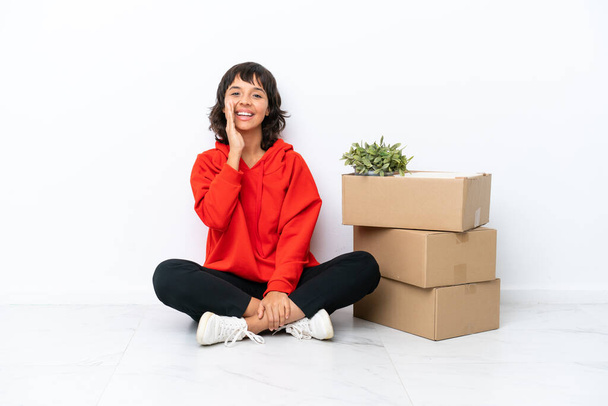 Young girl moving in new home among boxes isolated on white background shouting with mouth wide open - Photo, Image