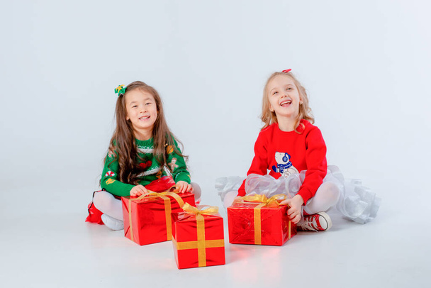 白い背景にクリスマスプレゼントのある2人の女の子が - 写真・画像