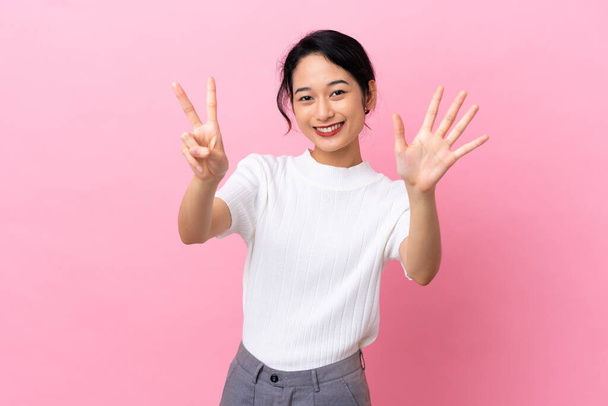 Young Vietnamese woman isolated on pink background counting seven with fingers - Фото, изображение