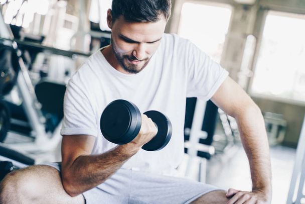 Wellness men lifting dumbbell weight hand in gym healthy life style - Photo, Image