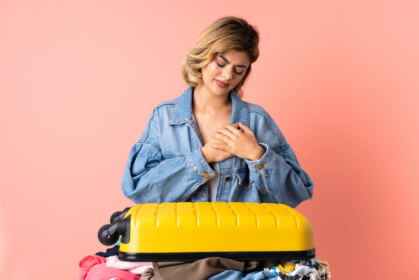 tiener vrouw met salade geïsoleerd op blauwe achtergrond met een pijn in het hart - Foto, afbeelding