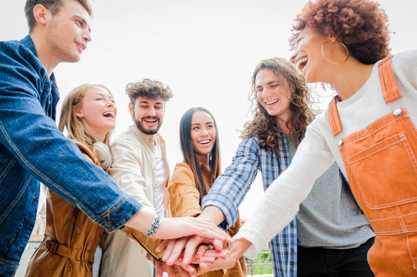 Retrato de amigos felices de la universidad apilándose de las manos, mostrando unidad y unidad - Cultura Diversa Estudiantes celebrando juntos - Concepto de amistad - Foto, imagen