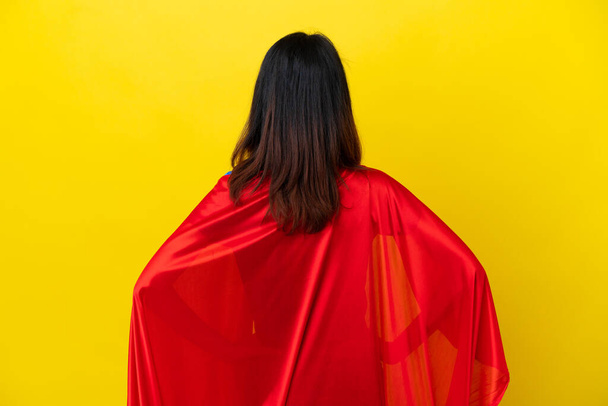 Super hero Vietnamese woman isolated  on yellow background in back position - Foto, Imagem