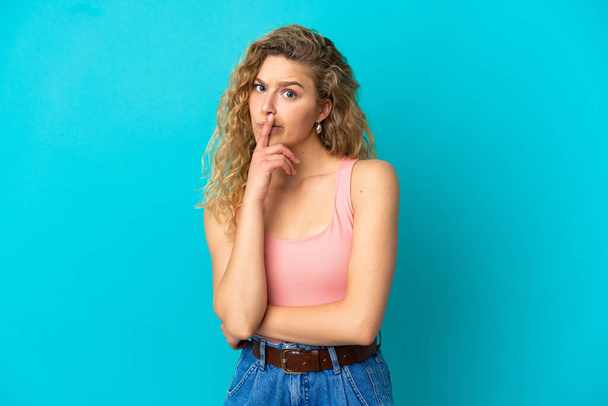 Junge blonde Frau isoliert auf blauem Hintergrund mit Zweifeln beim Nachschauen - Foto, Bild