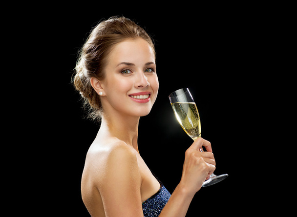 smiling woman holding glass of sparkling wine - Zdjęcie, obraz