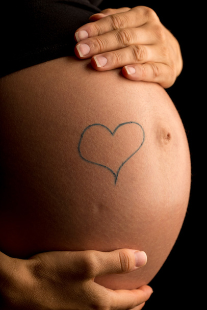 Cuore disegnato a mano sulla pancia di una donna incinta
 - Foto, immagini