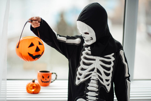 boy in halloween costume holding pumpkin lantern - Foto, Imagen