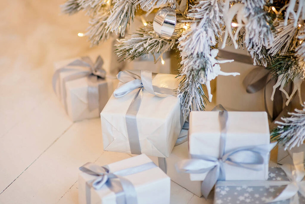 festively wrapped boxes under Christmas tree - Foto, afbeelding