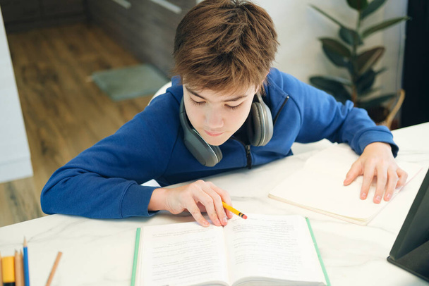 Дистанційне навчання онлайн-освіти. Хлопчик вчиться вдома і робить шкільне домашнє завдання. Навчання на домашній дистанції
. - Фото, зображення