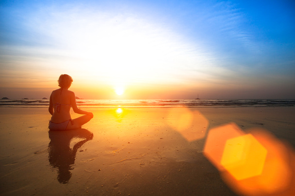 Yoga woman sitting on sea coast - Photo, Image
