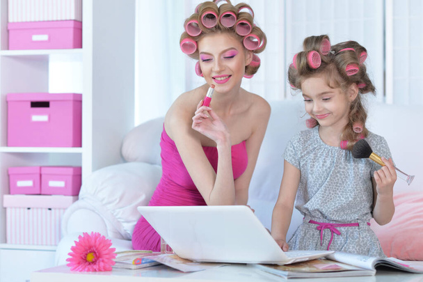  mother and little daughter with laptop  applying  make up  - Foto, imagen