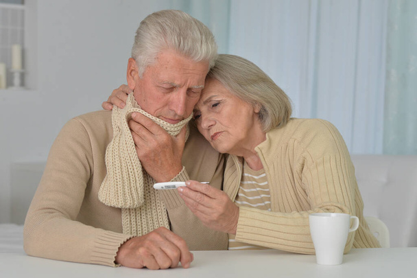 ill senior couple with thermometer at home  - Photo, Image