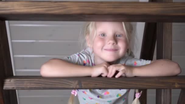 Boldog kislány a lépcsőn egy fa létra belsejében egy vidéki házban - Felvétel, videó