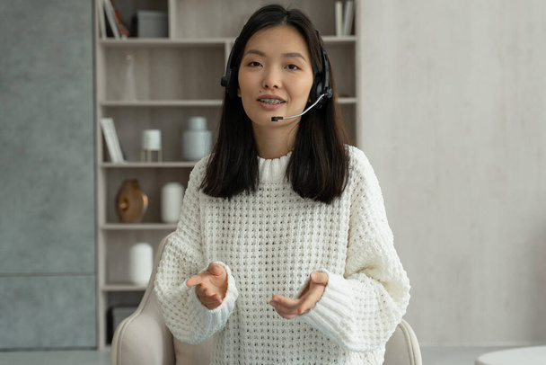 Ázsiai nő headsettel, kamerával beszél, video call video konferencia üzleti partnereivel - Fotó, kép