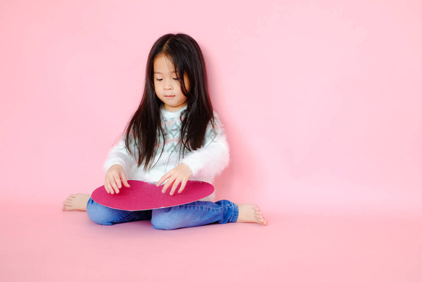 retrato bonito asiático criança menina no rosa fundo com vermelho coração sinal valentine dia no amor conceito - Foto, Imagem