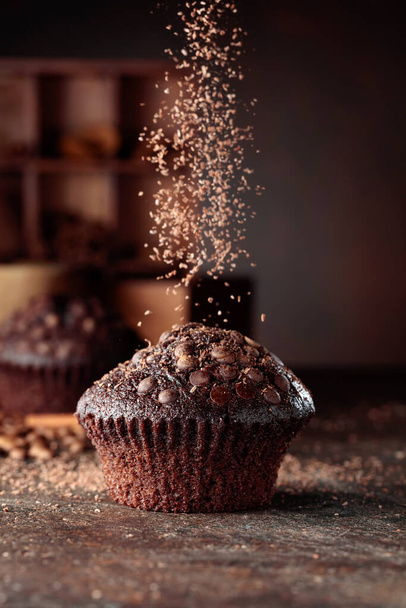 Delicious fresh chocolate muffins on a brown background. - Фото, изображение