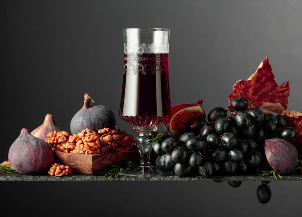 Vörös desszertbor fügével, dióval és kék szőlővel. Fénymásolási hely. - Fotó, kép