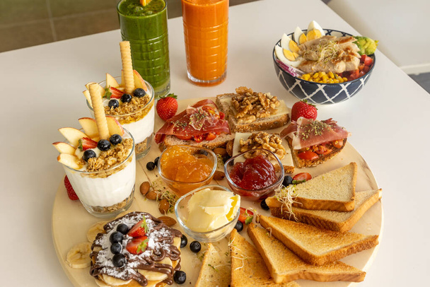 Chutné rozmanité bruschety a sendviče u mísy salátu a osvěžujících nápojů - Fotografie, Obrázek