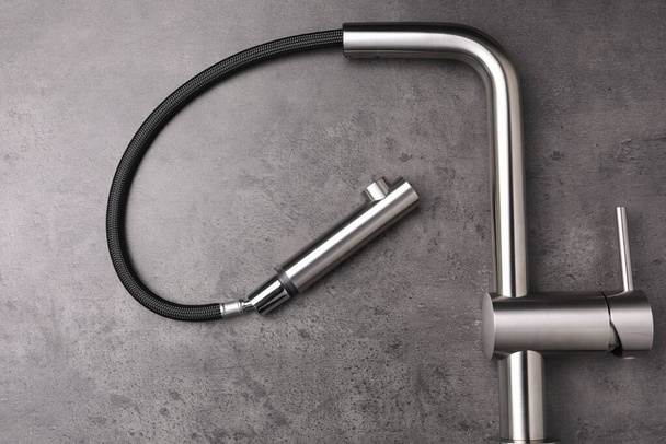 Modern pull out kitchen faucet on grey table, top view - 写真・画像