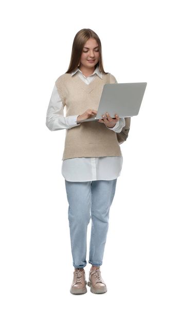 Teenage student with backpack using laptop on white background - Photo, image