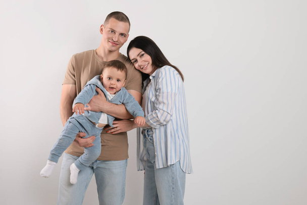 Portrait of happy family with little child on light background. Space for text - Photo, image