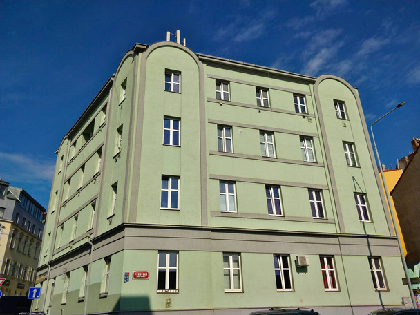 Prague, Czech Republic - October 2, 2021: Old style municipal corner apartment building with green facade during beautiful day. - Photo, Image