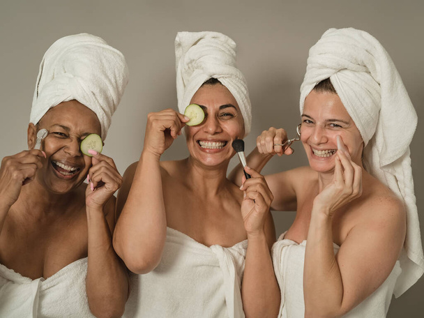 Счастливые женщины, ухаживающие за кожей в течение дня - Концепция здоровья и самообслуживания людей - Фото, изображение