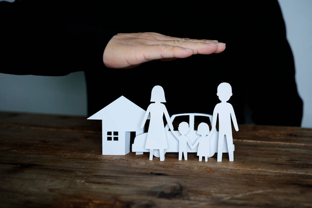 Concept of insurance with hands over a house, a car and a family - Foto, Bild