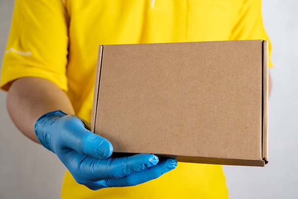 Delivery man holding cardboard boxes in rubber gloves, copy space. Fast and free Delivery transport . Online shopping and Express delivery - Фото, изображение