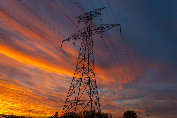 Estrutura de eletricidade com céu vermelho nascer do sol com nuvens. Volume elevado - Foto, Imagem