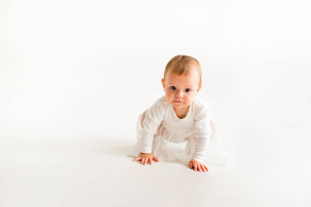 Cute baby on a white background in a white bodysuit. - Foto, imagen
