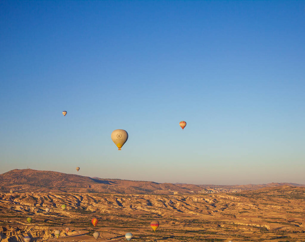 Kapadocja, Nevsehir, Turcja-wrzesień-2021: Błękitne niebo i balony na ogrzane powietrze. Szympansy wróżki.Widok z góry. Znany jako "Kapadokya" w Turcji - Zdjęcie, obraz
