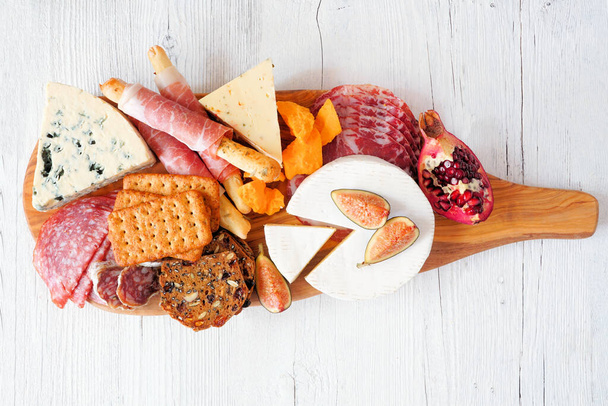 Charcuterie board of meat, cheese and appetizers. Top down view over a white wood background. - Fotó, kép