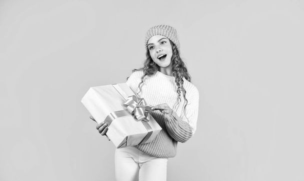 New year new me. Christmas gift in hand. Christmas concept. Happy little smiling girl with christmas gift box. kid hold present box yellow background. Happy Christmas and New Year - 写真・画像