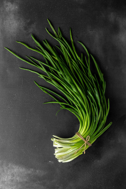 a bunch of green fresh onions or scallion on a dark background, top view - Photo, Image