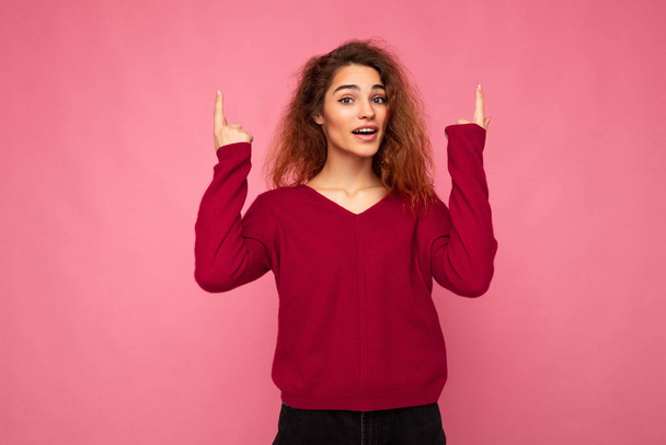 Photo of pretty astonished young woman pointing fingers up at copyspace presenting incredible ads promo with impressed scream wow omg emotions wearing good look outfit isolated over background with - Photo, Image