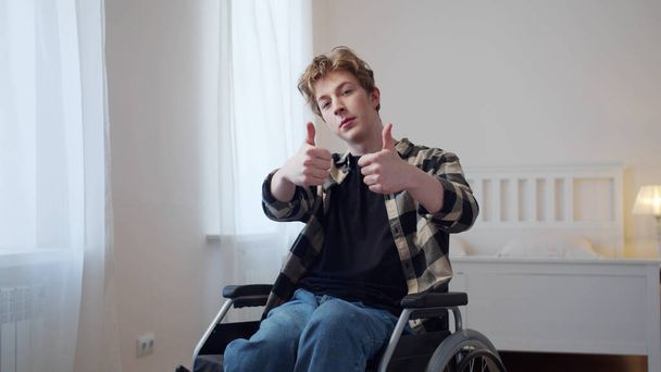 Egy jóképű, fogyatékos férfi ujjal mutogat. - Fotó, kép